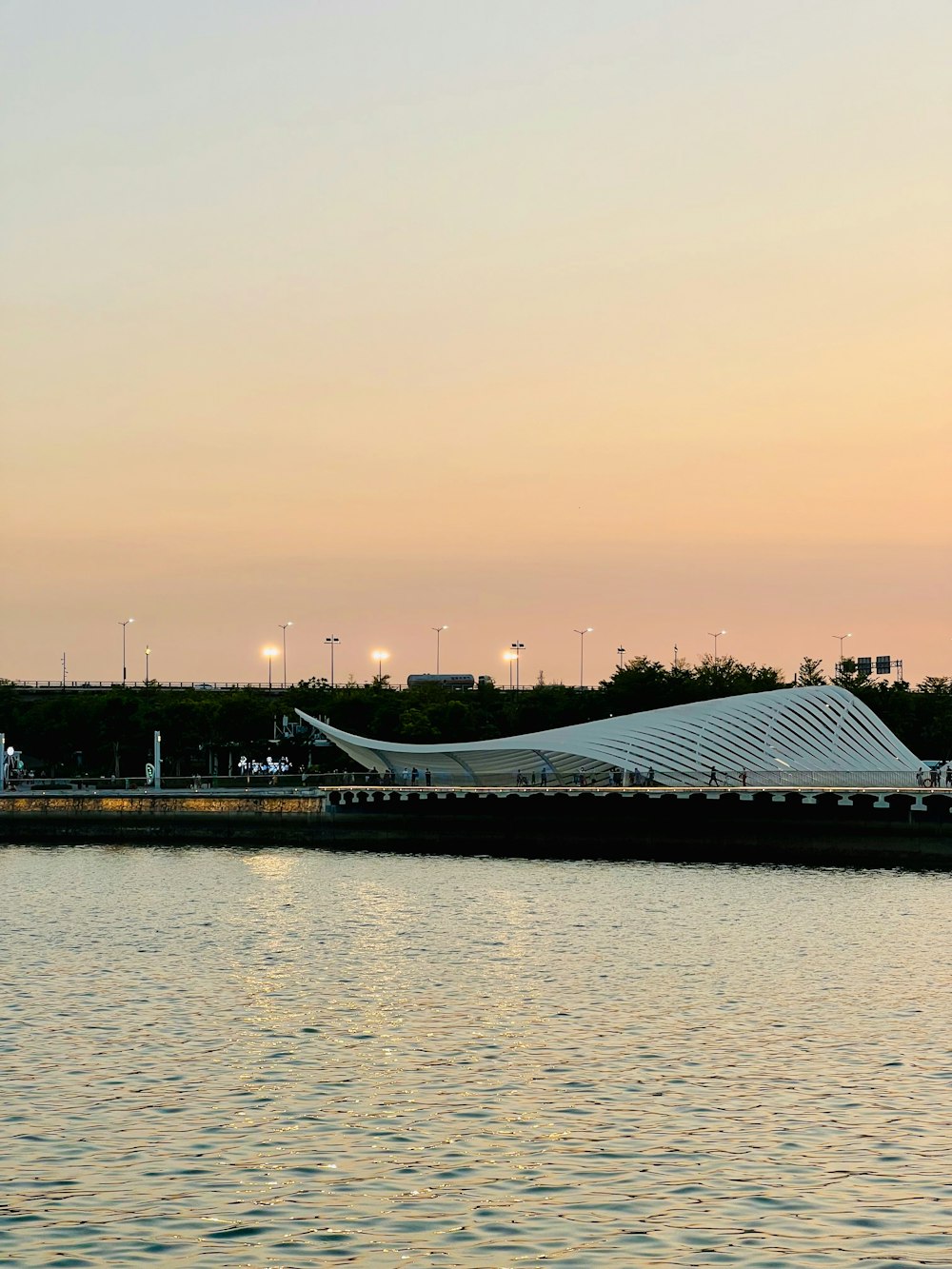 a building with a glass roof by a body of water