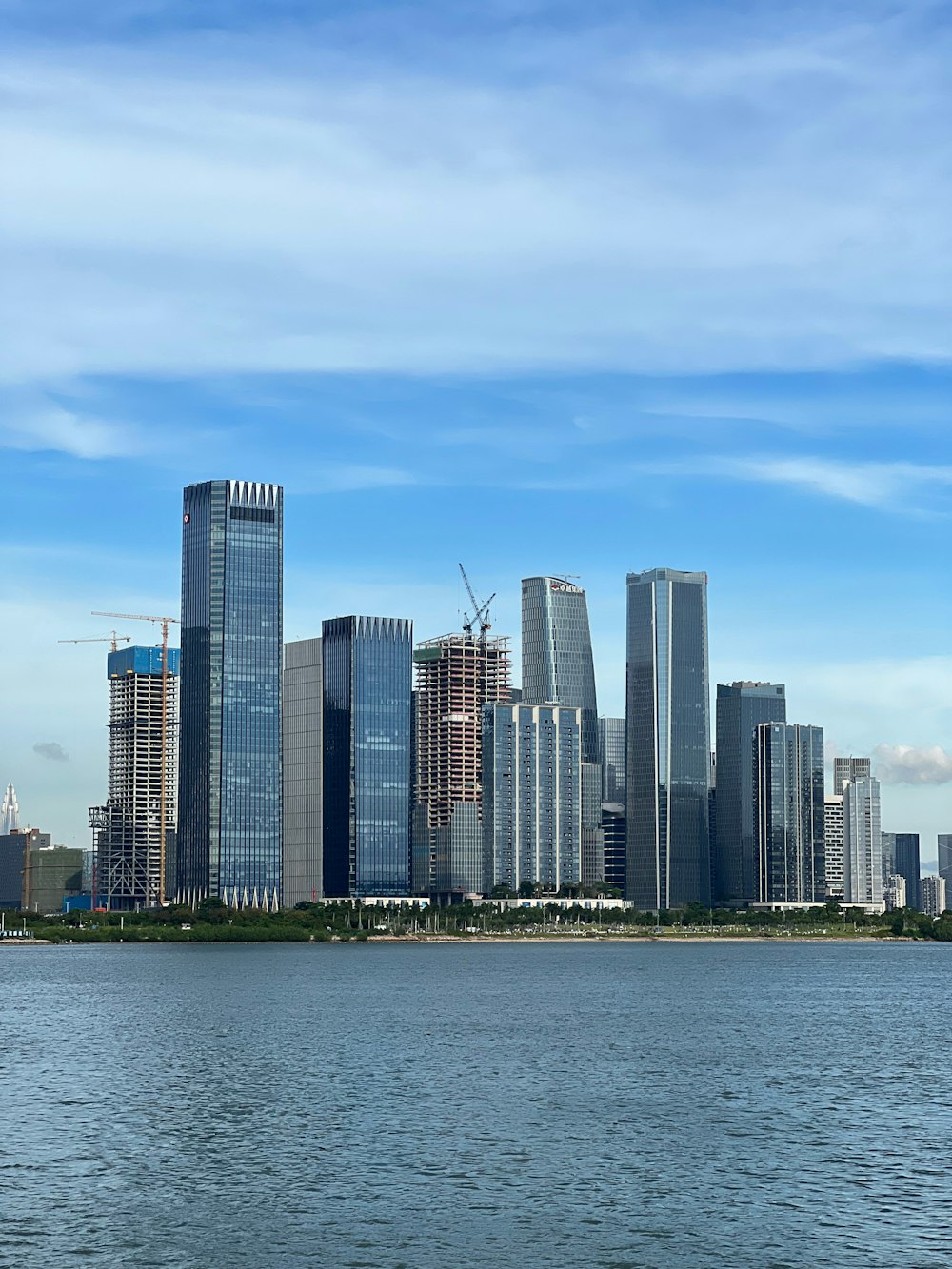 a city skyline with a body of water in the foreground