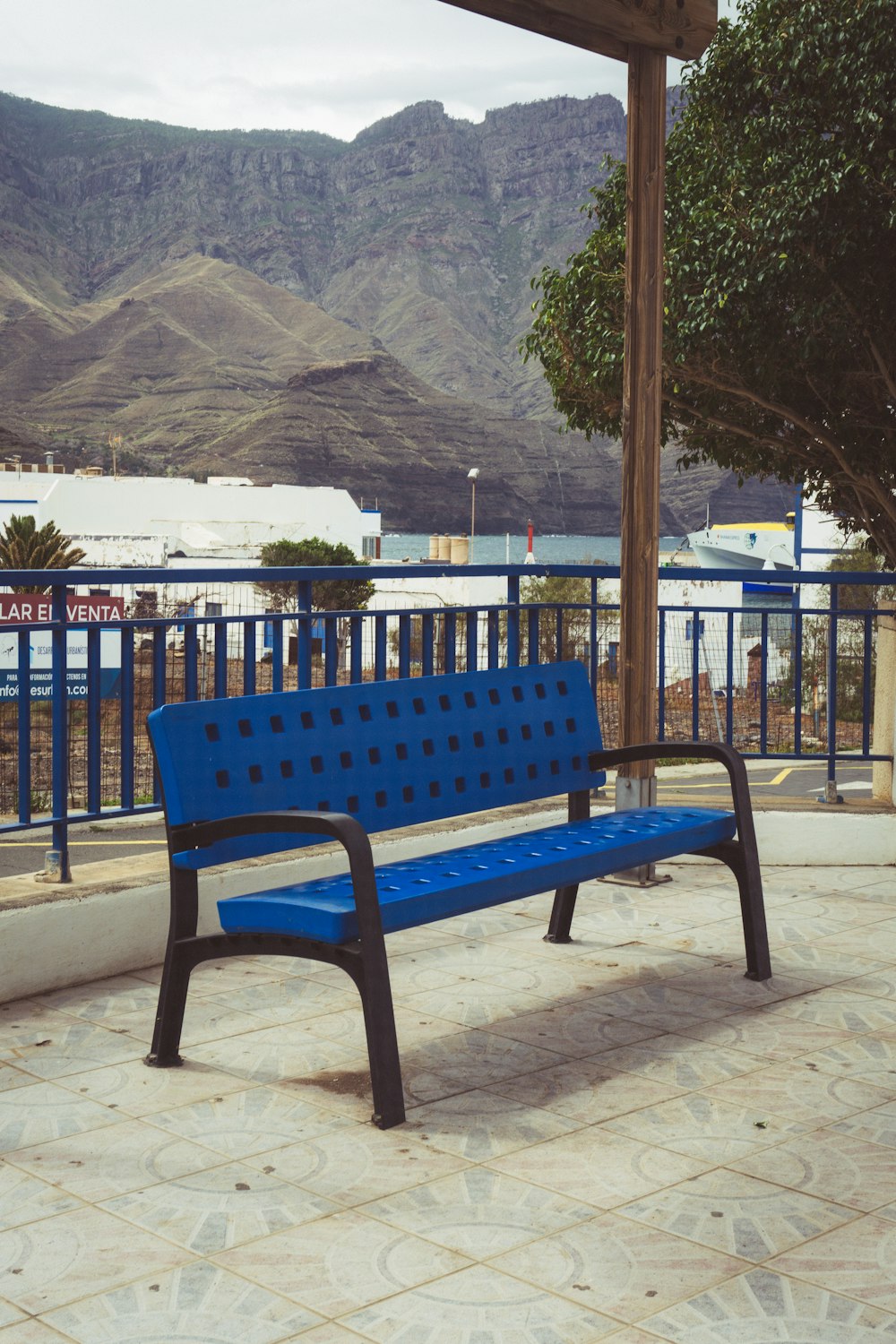 a blue bench sits on a sidewalk