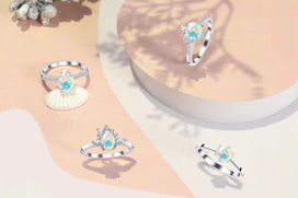 Silver rings arranged artistically on a smooth stone with subtle shadows.