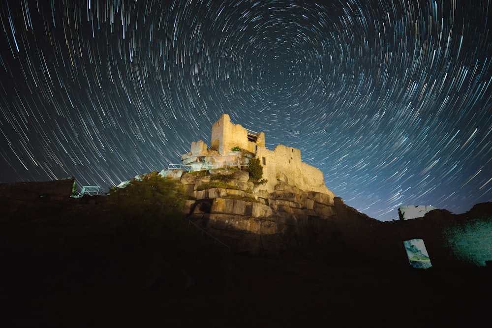 a large rock formation with lights in the sky above it