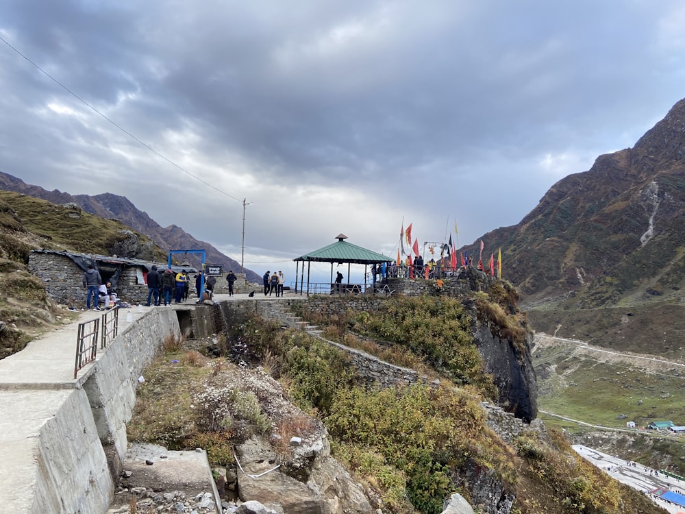 a group of people walking on a path in a mountainous region