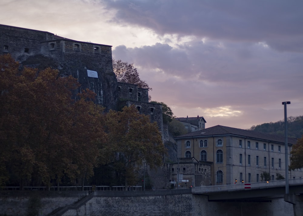 a stone wall with a bridge and buildings on the side