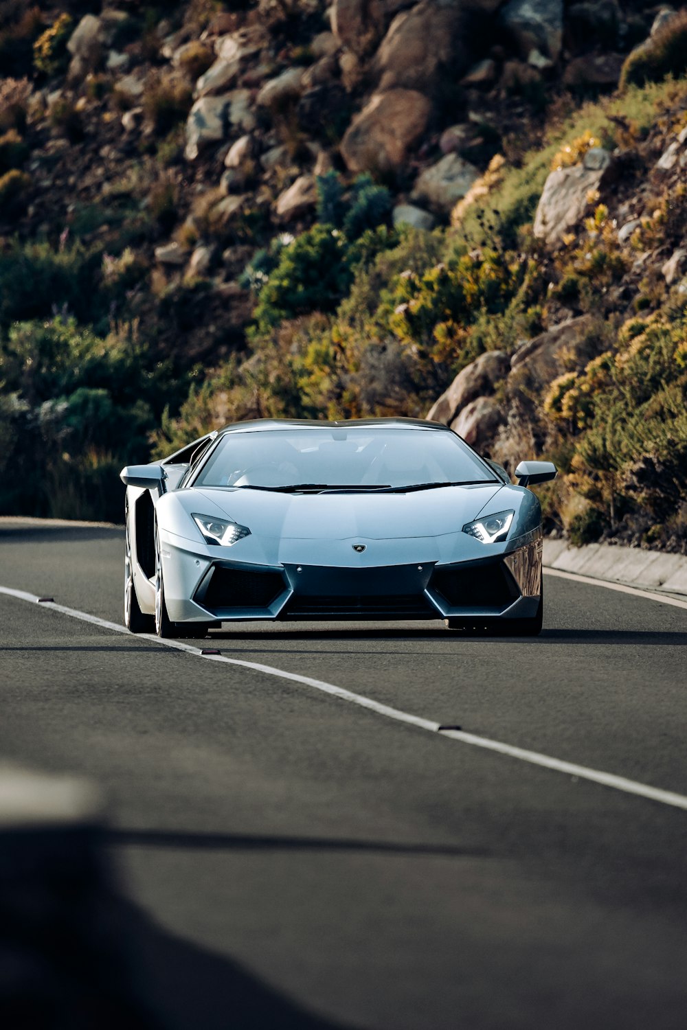 um carro esportivo dirigindo por uma estrada