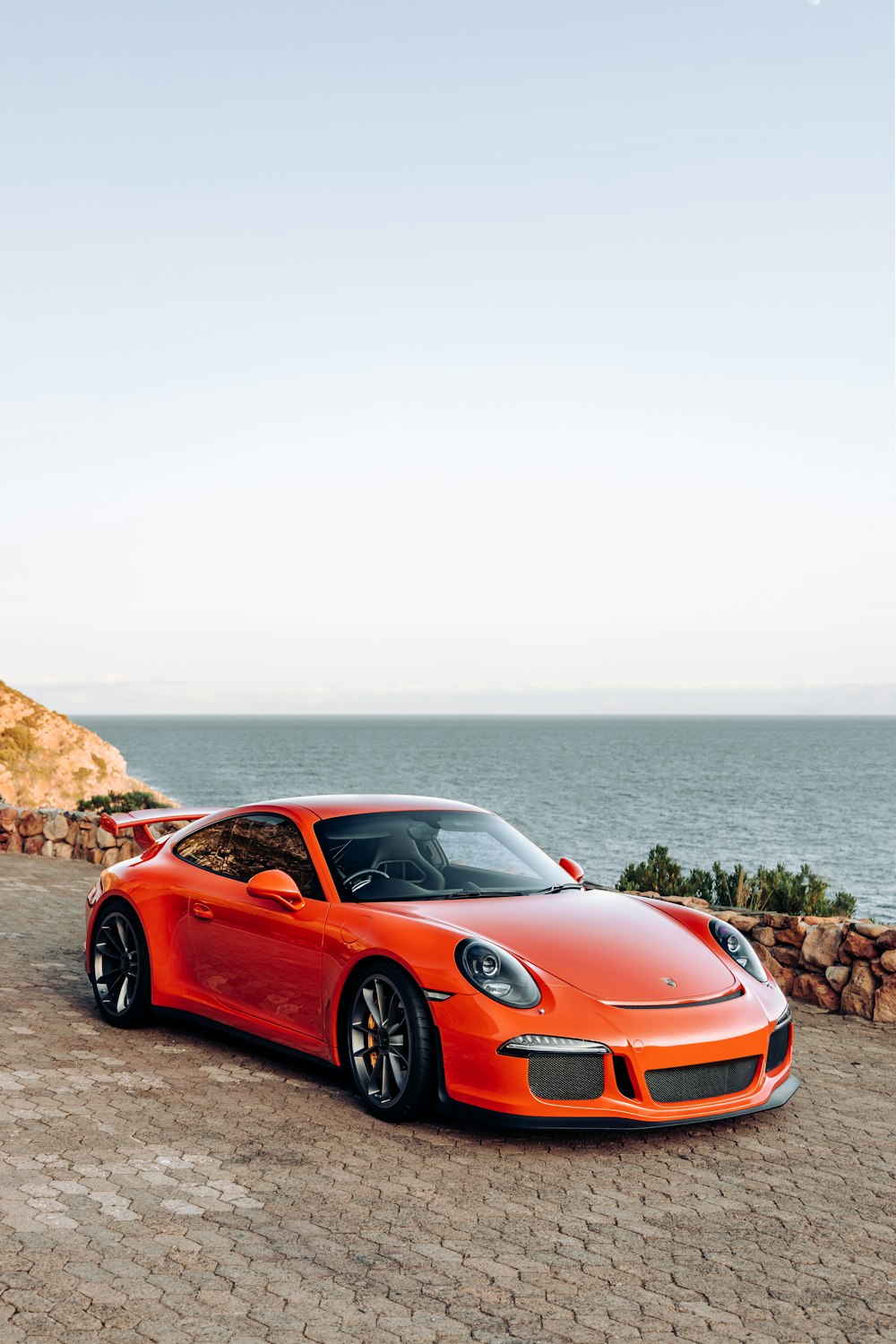 a car parked on a road by the water