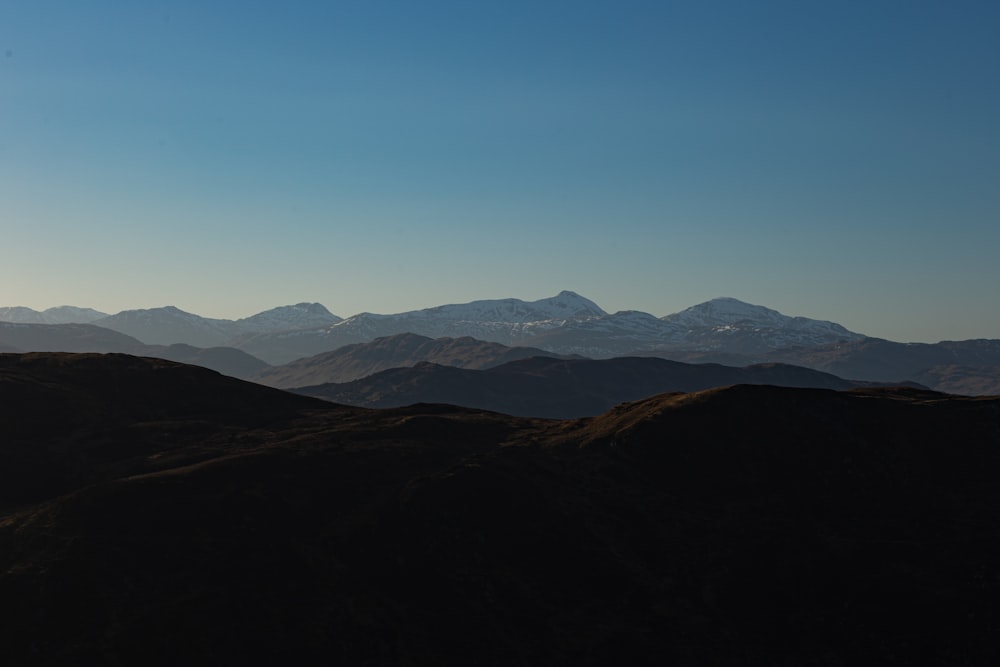 a landscape with hills and mountains in the background