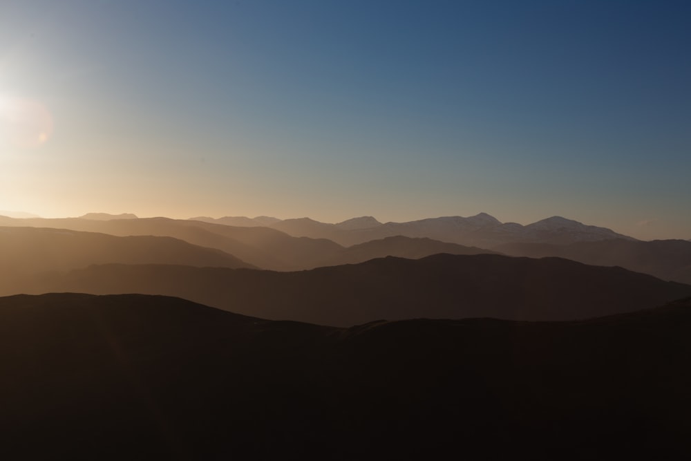 a landscape with hills and a blue sky