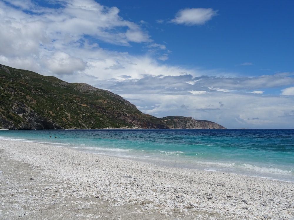 a beach with a hill in the background