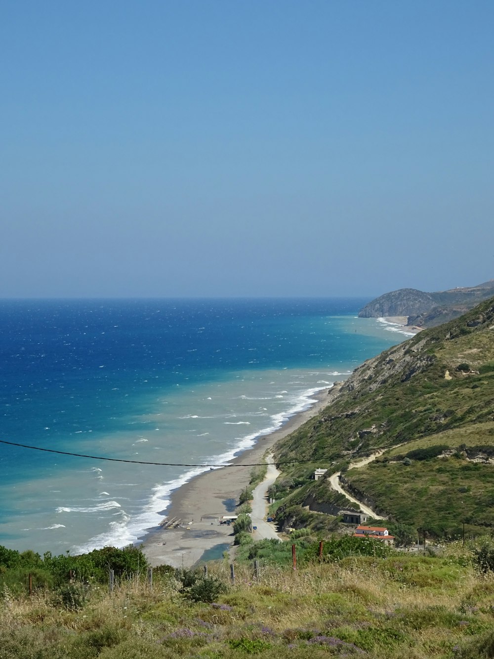 a beach with a road and grass