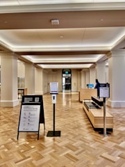 A friendly staff member assisting a visitor with paperwork at a public information desk