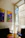 A cozy living room wall adorned with vibrant new art prints, sunlight streaming through a nearby window.