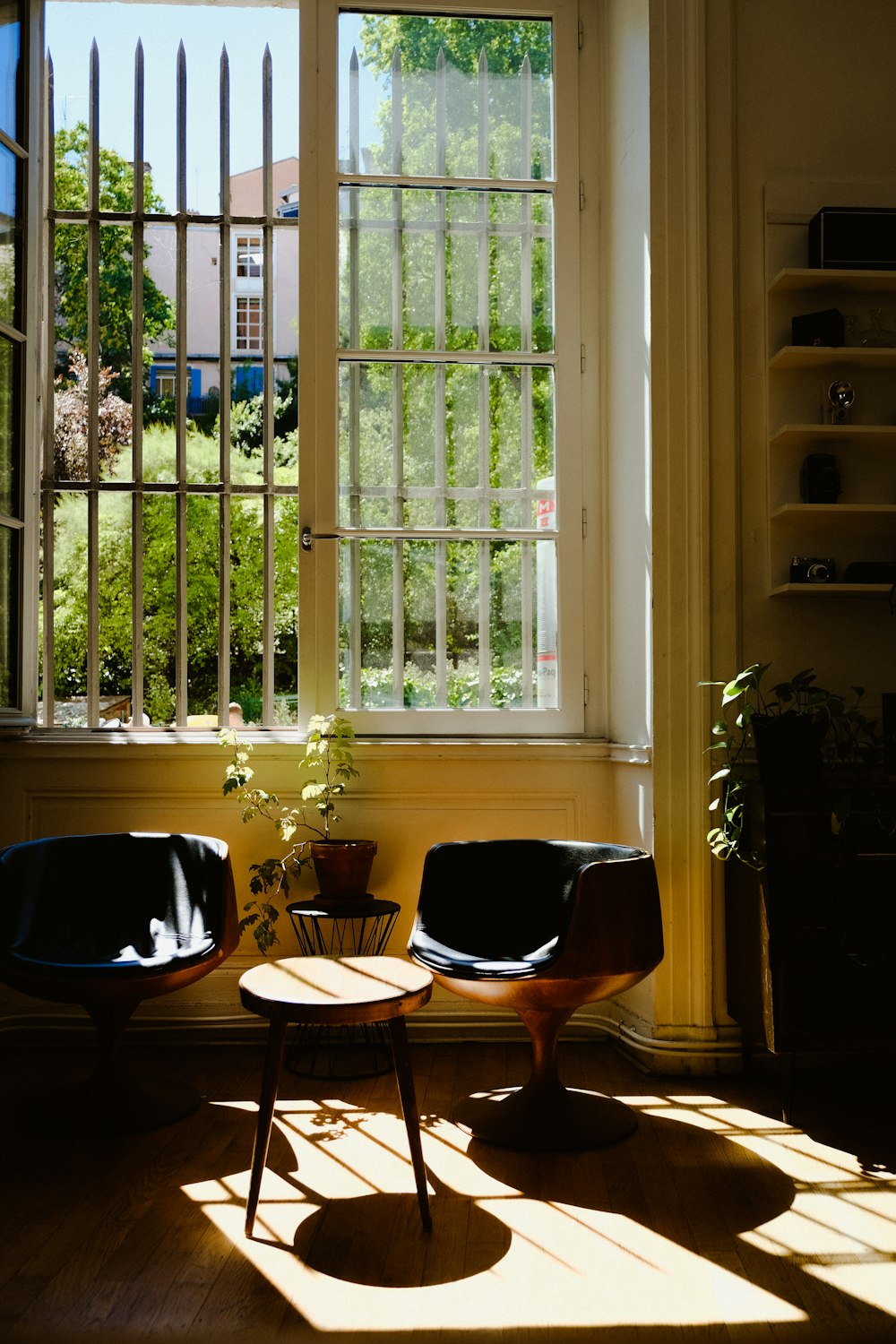 a room with a table chairs and a window with a view of the street