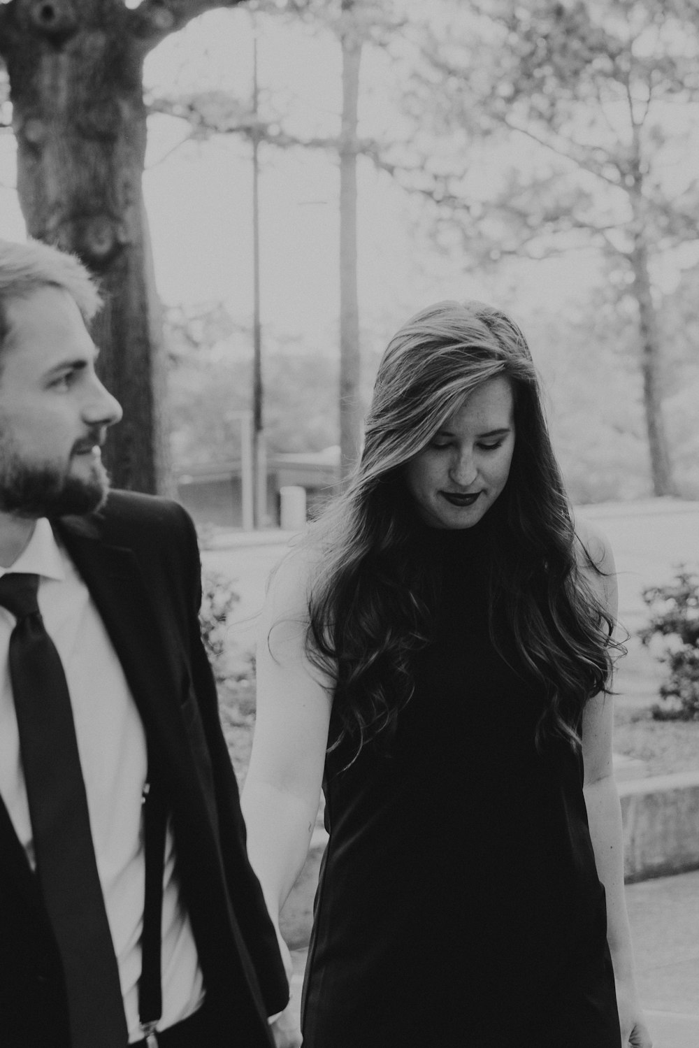 a man and woman standing next to each other outside