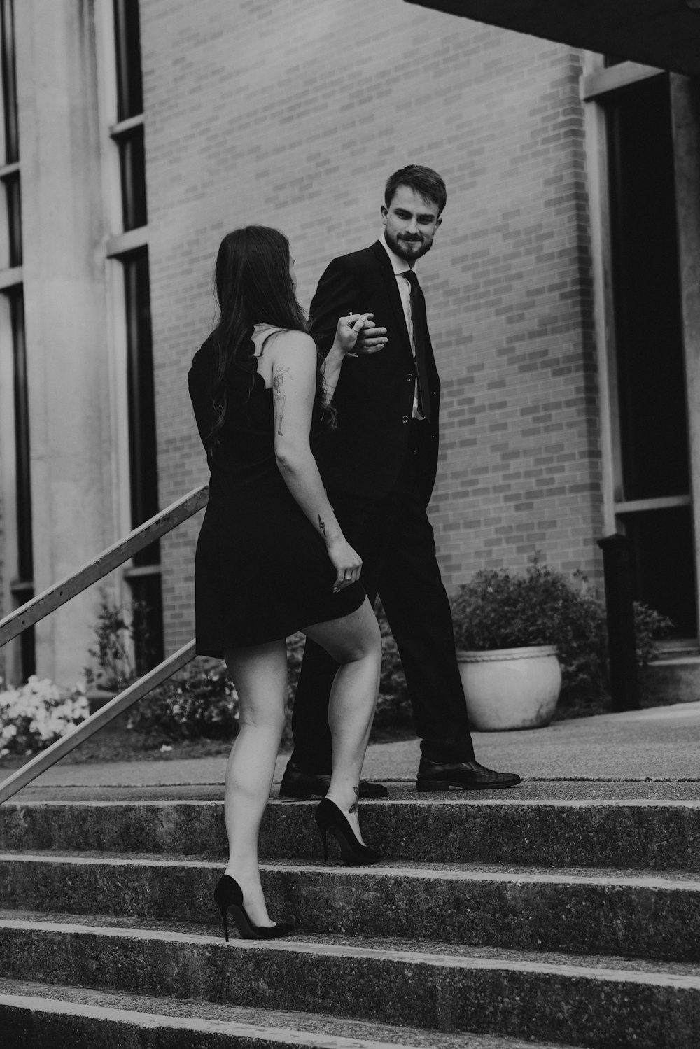 a man and woman posing for a picture on some steps