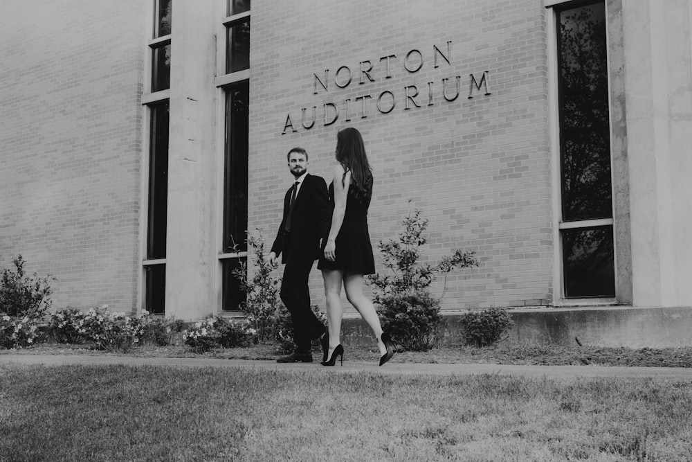 a man and woman posing for a picture outside of a building