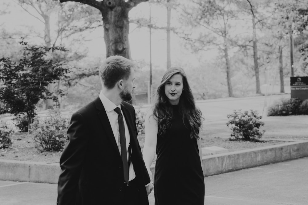 a man and woman walking down a sidewalk