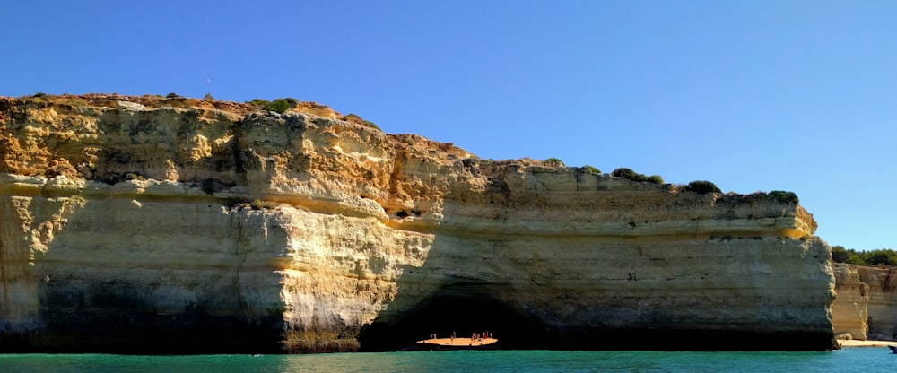 a cliff with a boat in the water