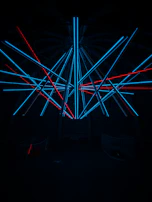 A bold geometric art piece with neon accents against a black background.