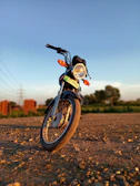 A close-up of a motorcycle parked beside a breathtaking canyon overlook during golden hour.