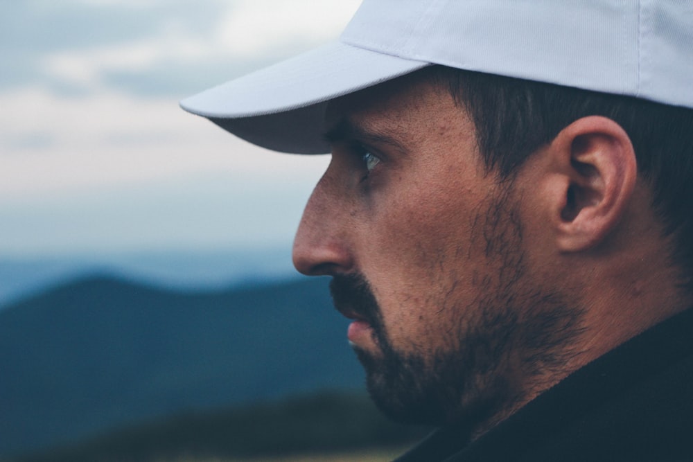 a man with a beard and a hat looking at the camera