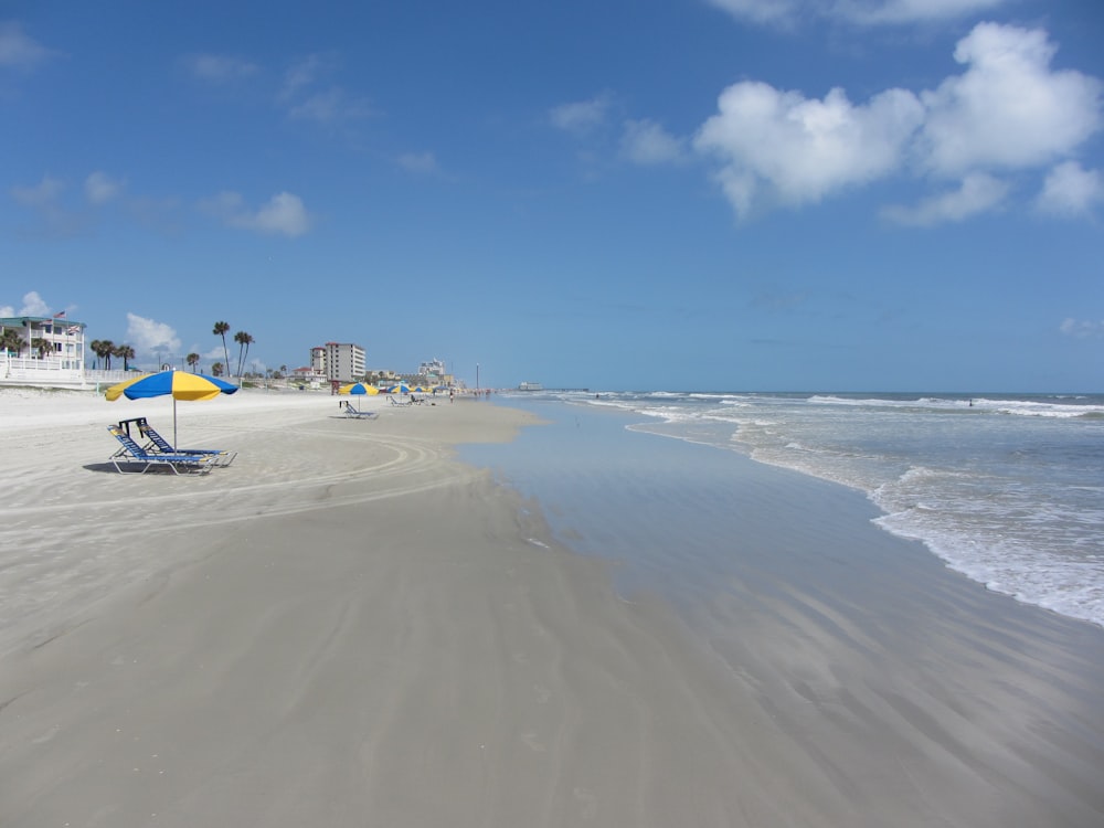 a beach with chairs and umbrellas