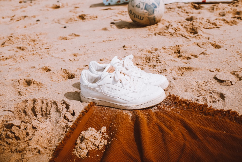 a pair of white shoes on sand