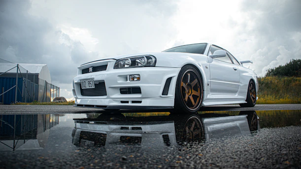 a white sports car parked on a wet road