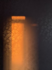 Soft lighting casting a warm glow over the suite’s maroon and gold decor.