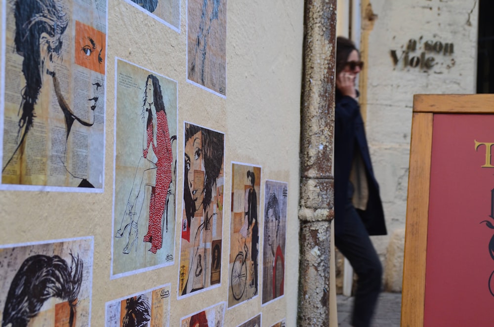 a person standing next to a wall with art on it