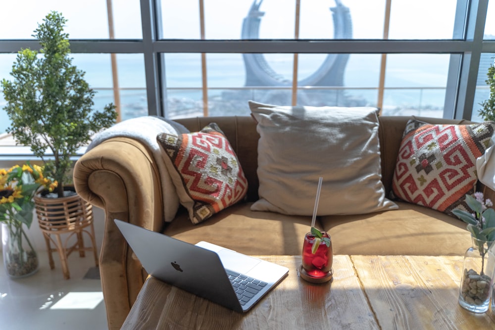 a couch with pillows and a laptop