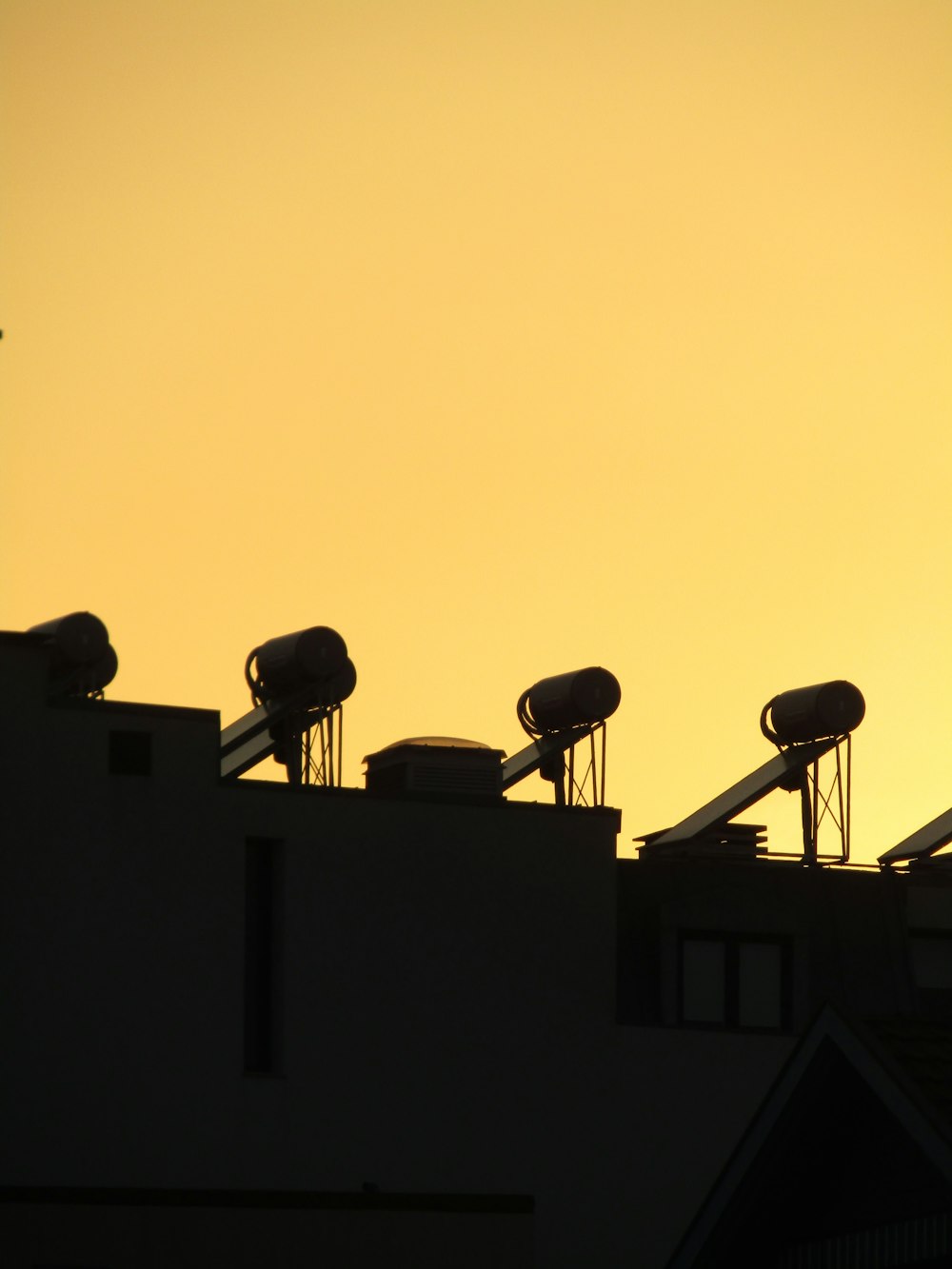 a silhouette of a satellite dish on top of a building