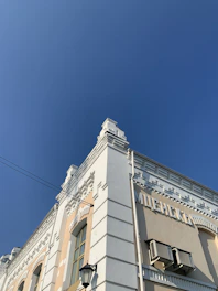 Before and after high-pressure cleaning of a historic building facade, showing clear contrast.