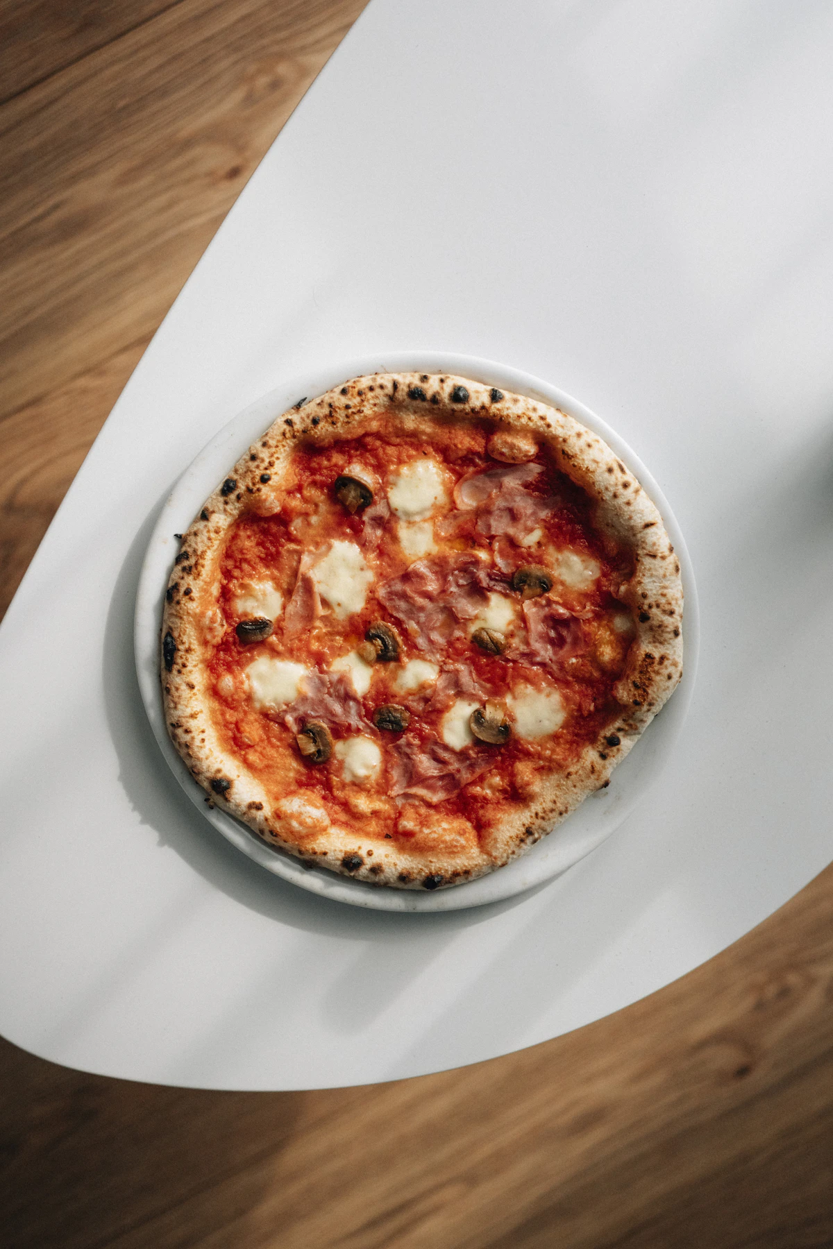 A pizza plated and ready to serve, crust blistered from the oven