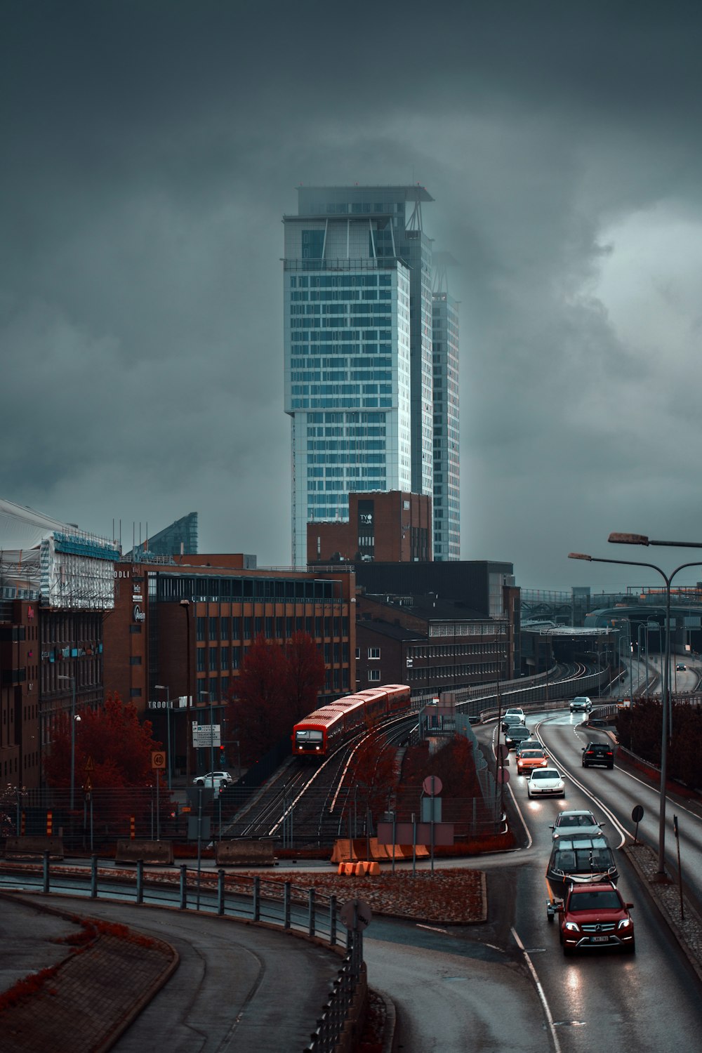 a city street with cars and a train on it