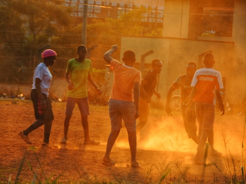 A vibrant group of young athletes practicing football on a sunny field.