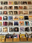 A collection of vinyl records displayed on a shelf, inviting guests to enjoy music.