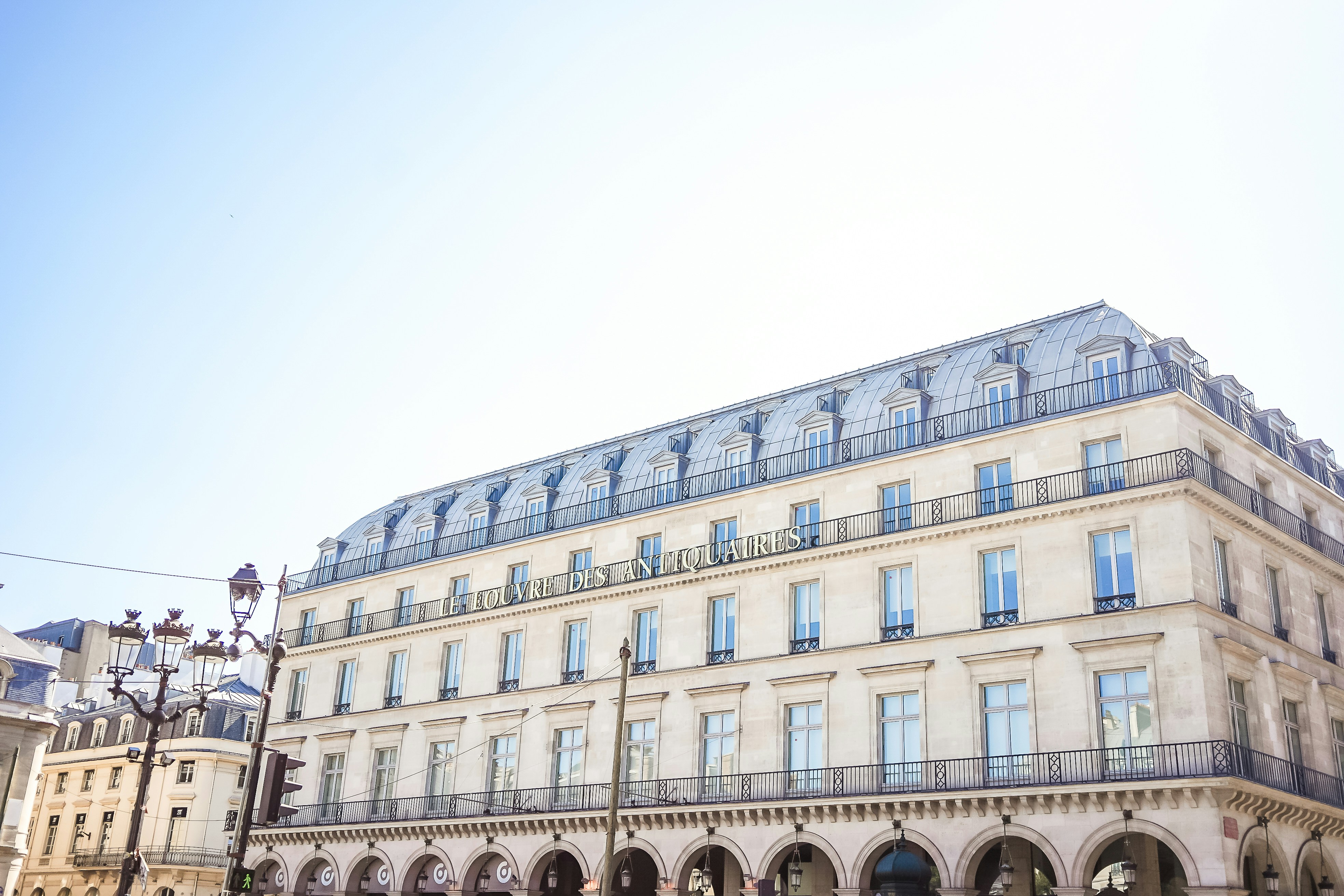 a large building with many windows, a french building in paris le louvre des antiquaires 