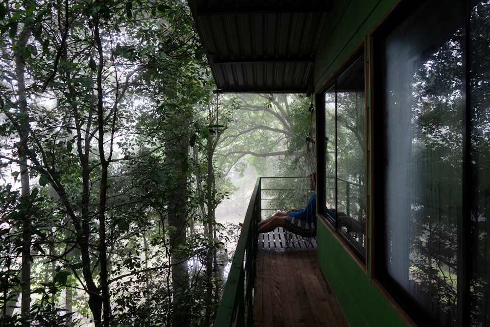 a person sitting on a chair outside a window