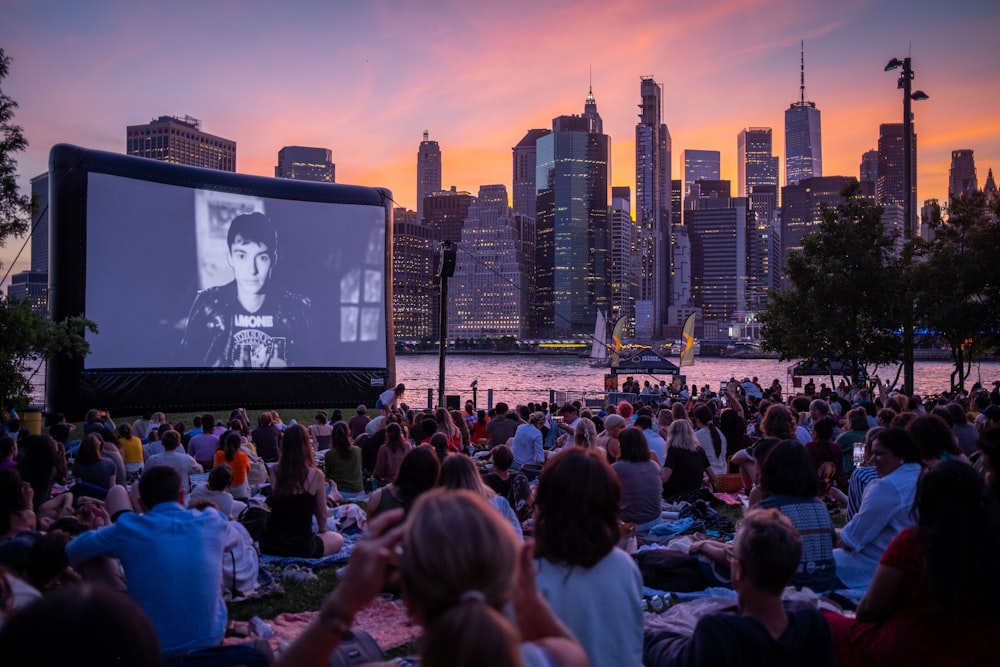 a large crowd of people watching a television screen