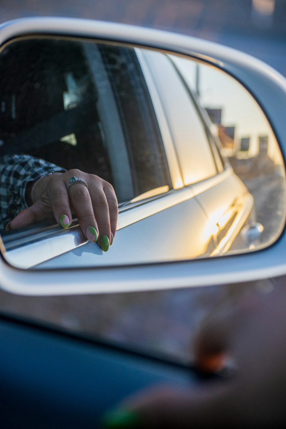 a person holding a ring in a car mirror