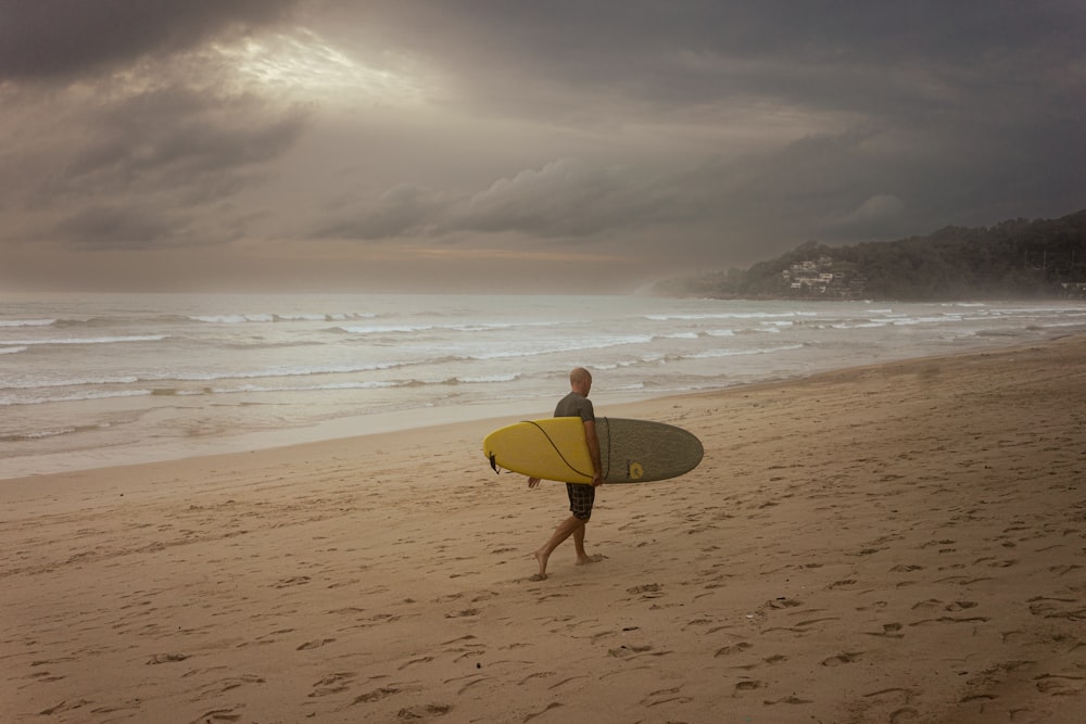 a person carrying a surfboard on a beach