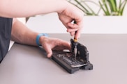 Close-up of a technician repairing a smartphone screen on a workbench.