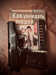 A smiling author holding a freshly printed book with a vibrant cover.