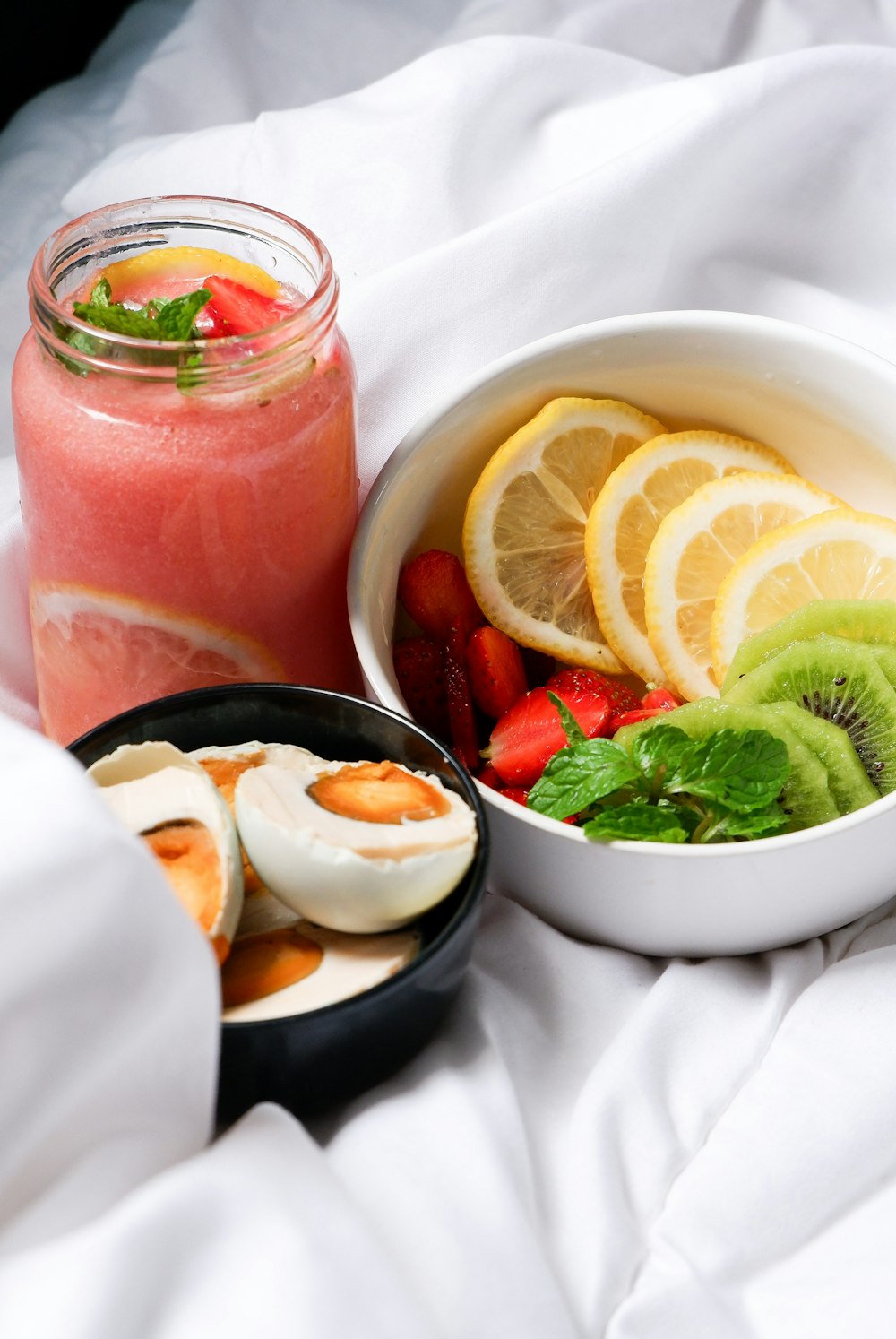 a glass jar with fruit and a glass of juice