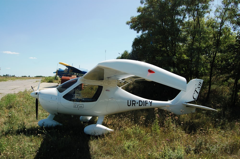 a small white airplane on the grass