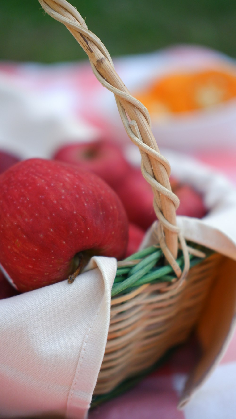 a hand holding a basket of red apples