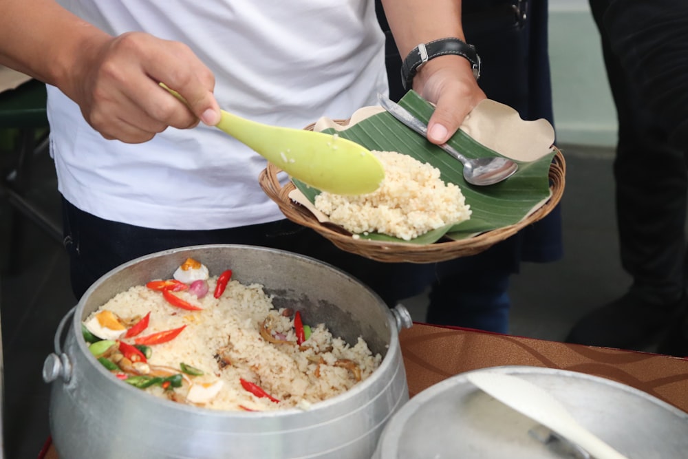 a person holding a green spoon over a bowl of food