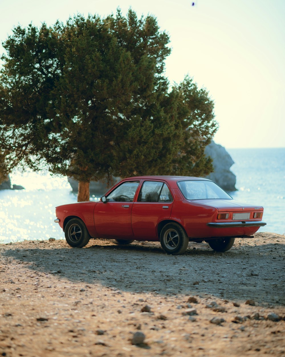 a red car parked on a beach