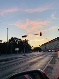 Traffic light glowing red at dusk on a busy city street.