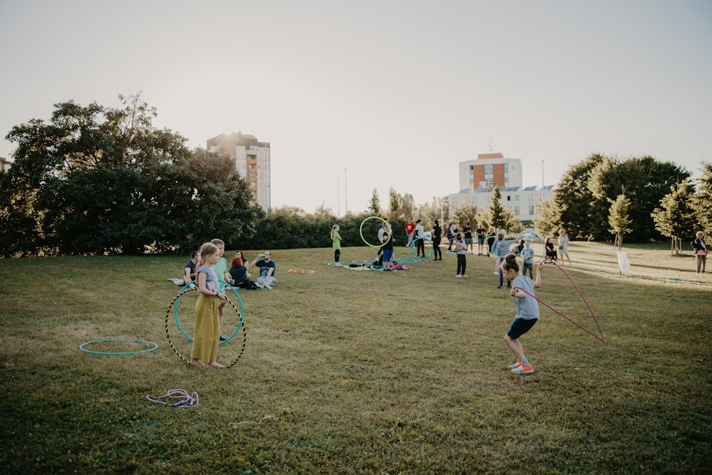 a group of people playing with hoops in a park